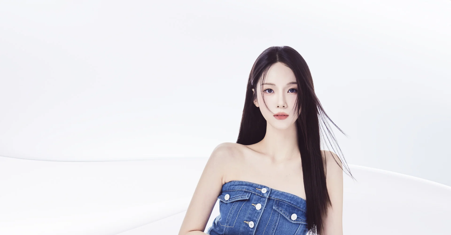 デニムのトップスを着た、長い黒髪の女性。