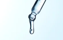 スポイトから透明な液体が滴り落ちる様子