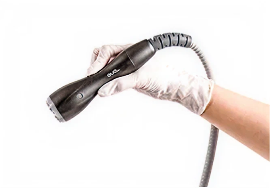 白い手袋をした手が、医療用ハンドピースを持っている。