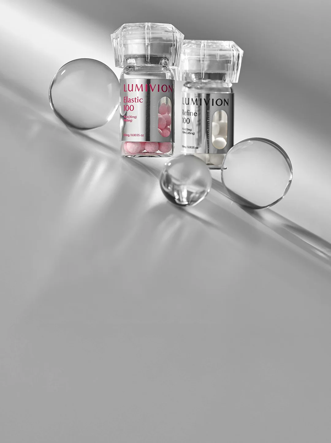 ルミビオンのElastic 100とRefine 100のボトル、透明な球体。