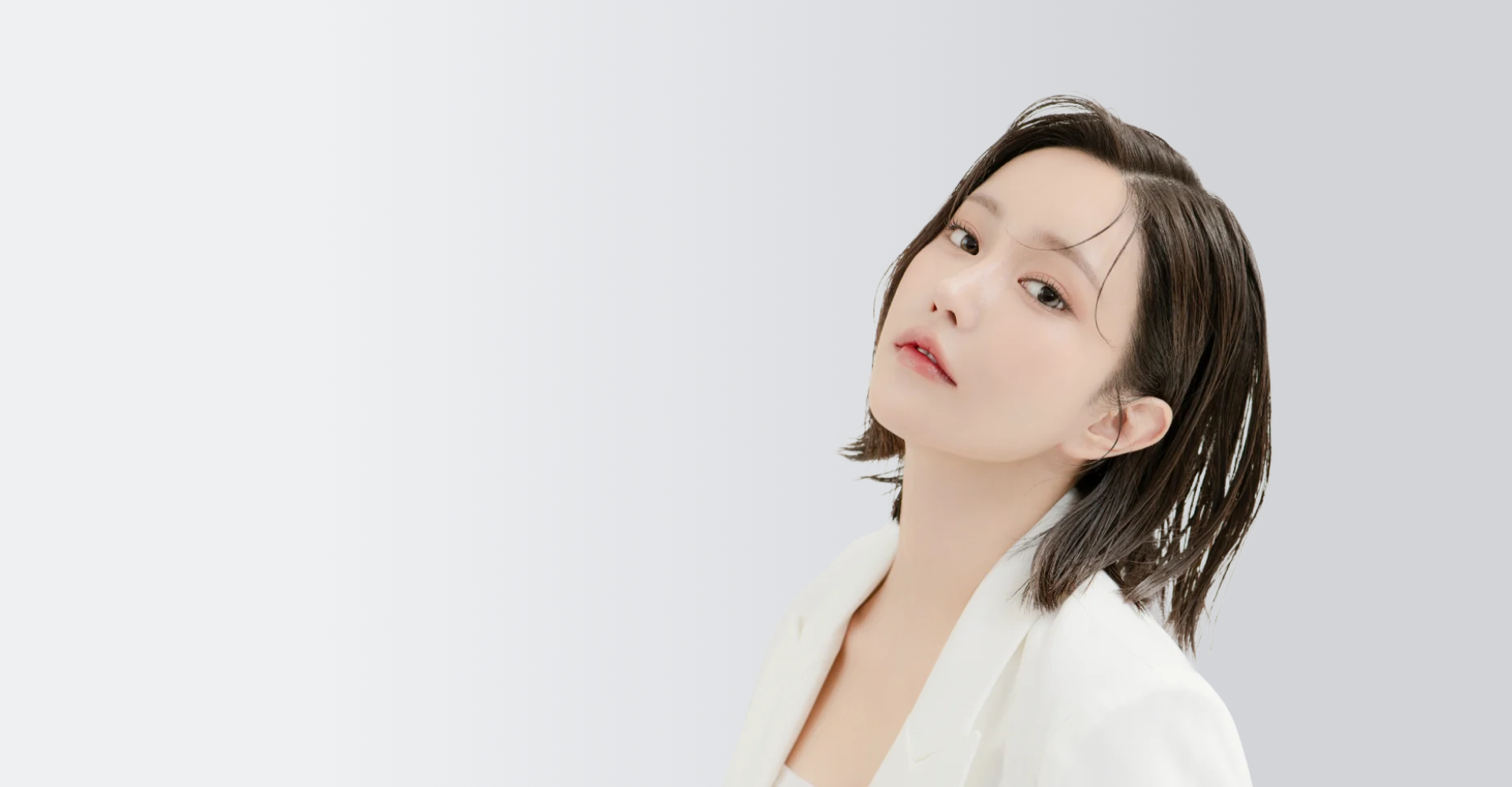 白いジャケットを着た、ショートヘアの女性